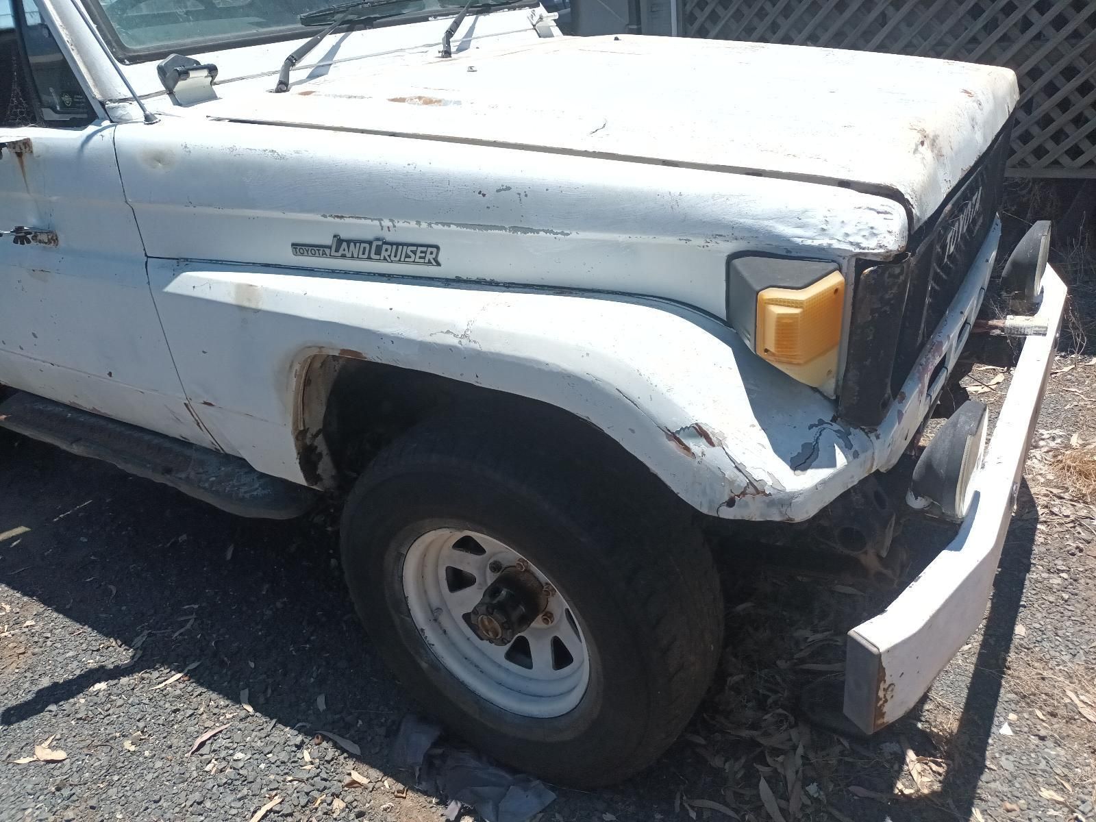 A White Toyota Land Cruiser is Parked on the Side of the Road — South West 4WD Wreckers In Brisbane, QLD