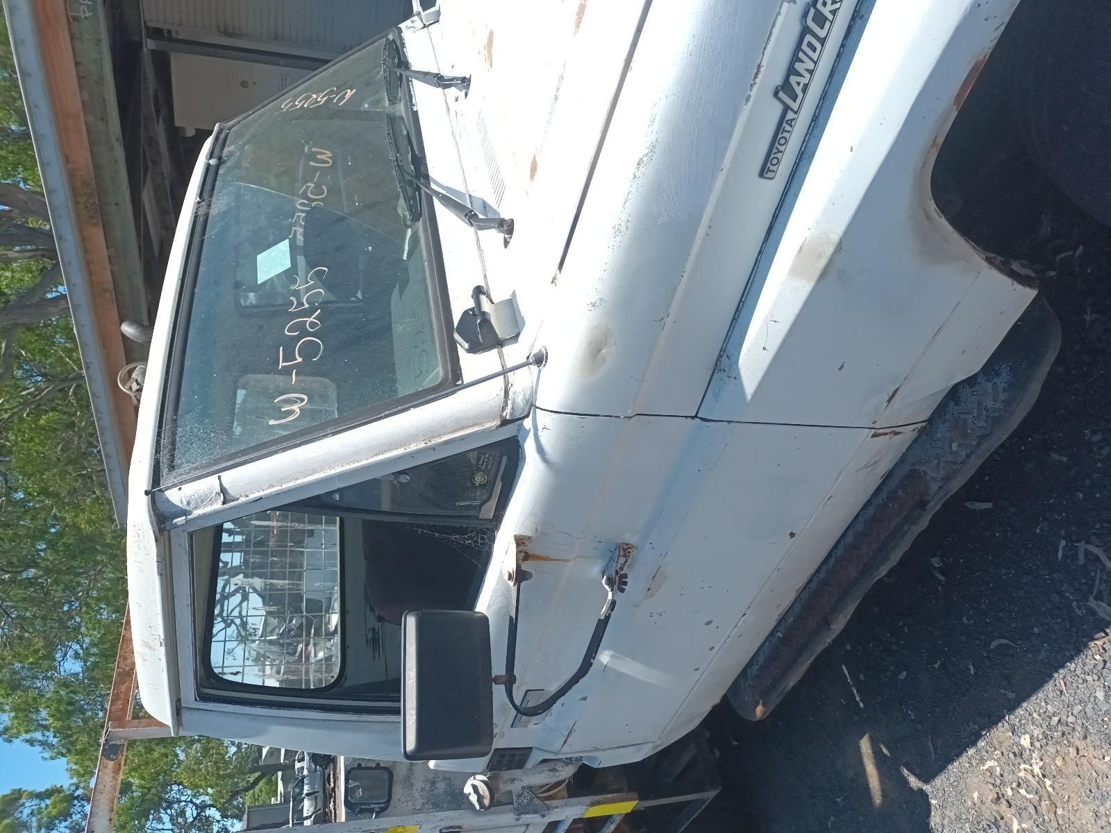 A White Truck with a License Plate That Says Toyota Land Cruiser — South West 4WD Wreckers In Brisbane, QLD