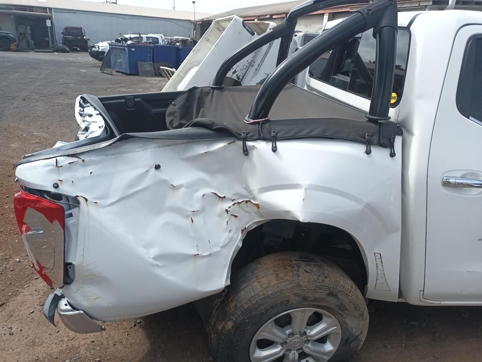 A White Truck with a Damaged Back End is Parked in a Dirt Lot — South West 4WD Wreckers In Brisbane, QLD