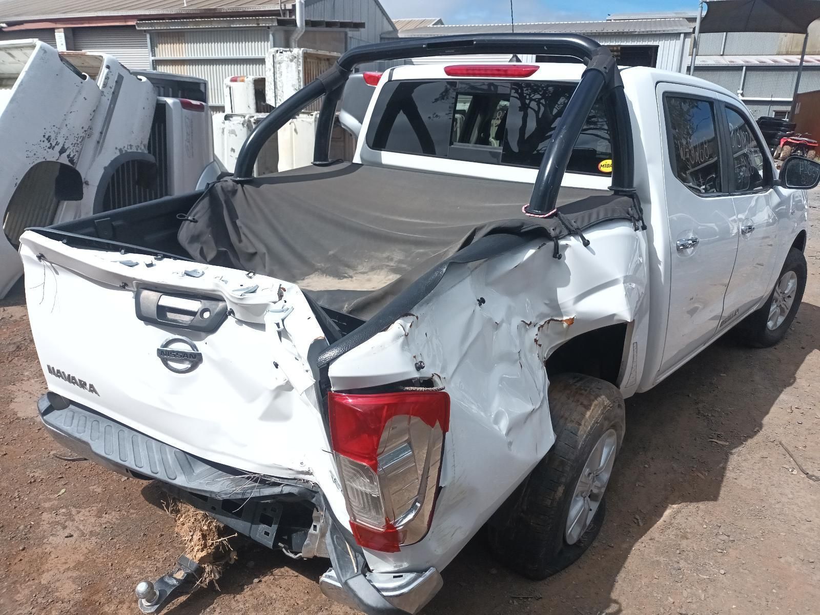 A White Truck with a Damaged Bed is Parked in a Dirt Lot — South West 4WD Wreckers In Brisbane, QLD