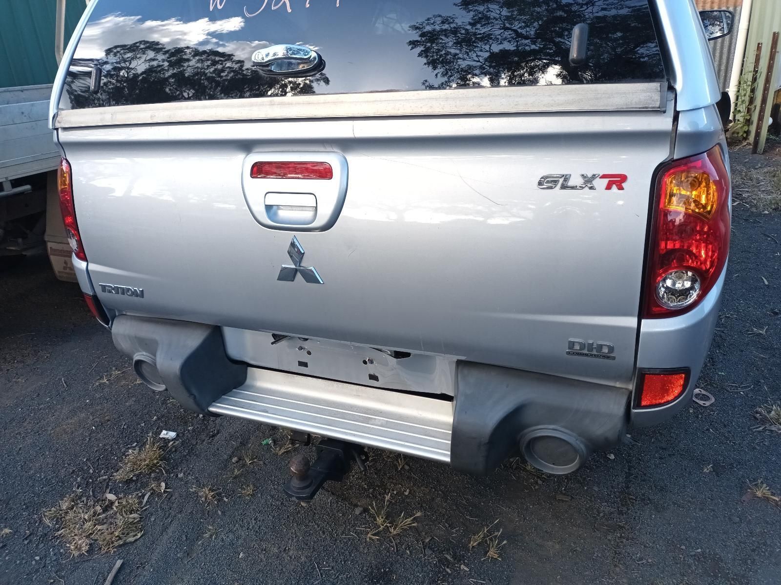 A Silver Mitsubishi Truck is Parked on the Side of the Road — South West 4WD Wreckers In Brisbane, QLD
