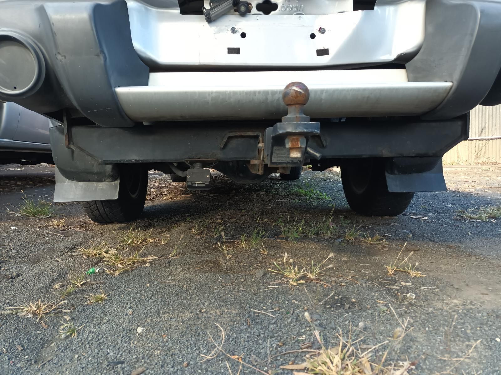 A Car with a Trailer Attached to It is Parked on the Side of the Road — South West 4WD Wreckers In Brisbane, QLD