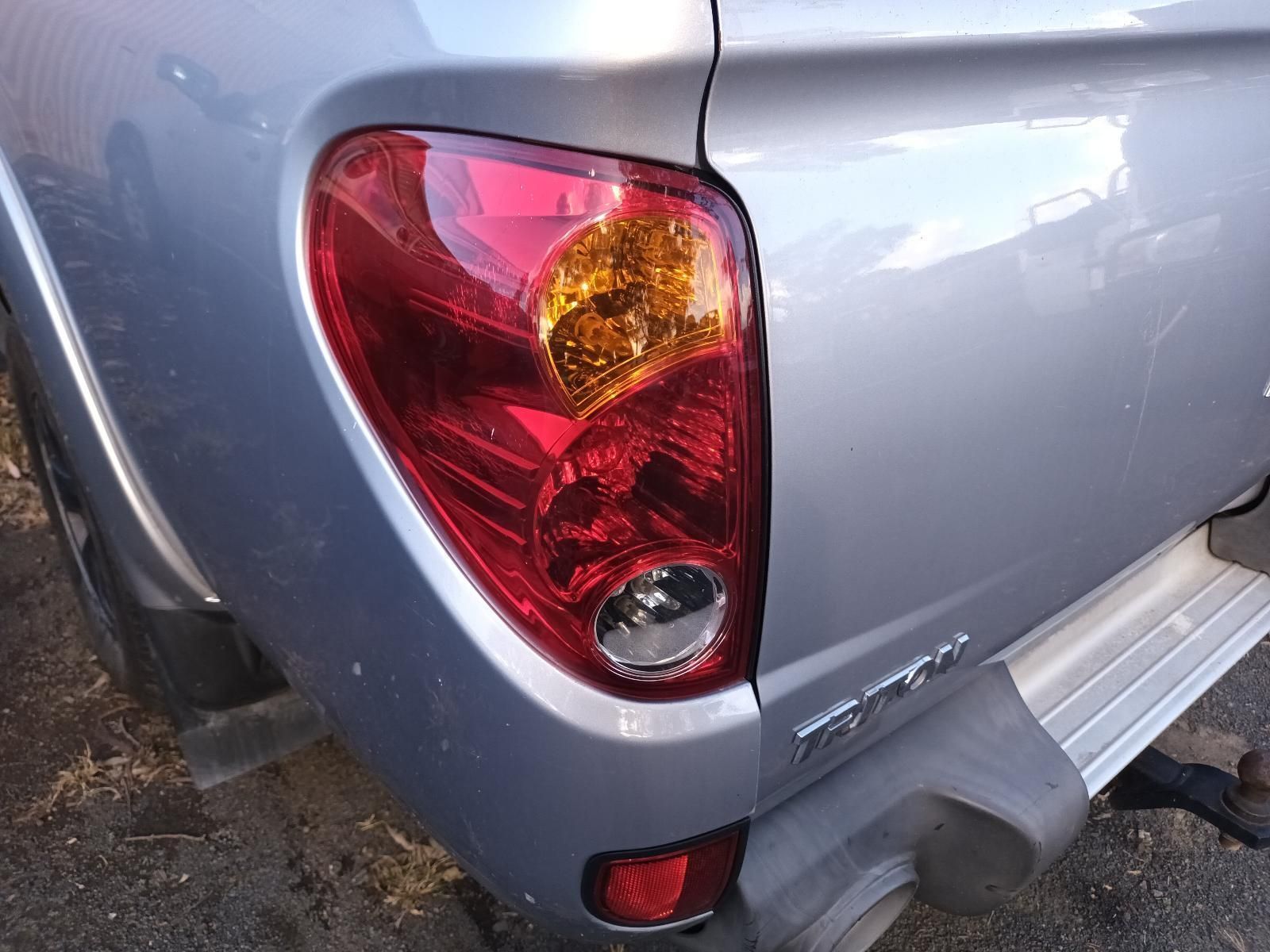 A Silver Truck with a Red Tail Light is Parked on the Side of the Road — South West 4WD Wreckers In Brisbane, QLD