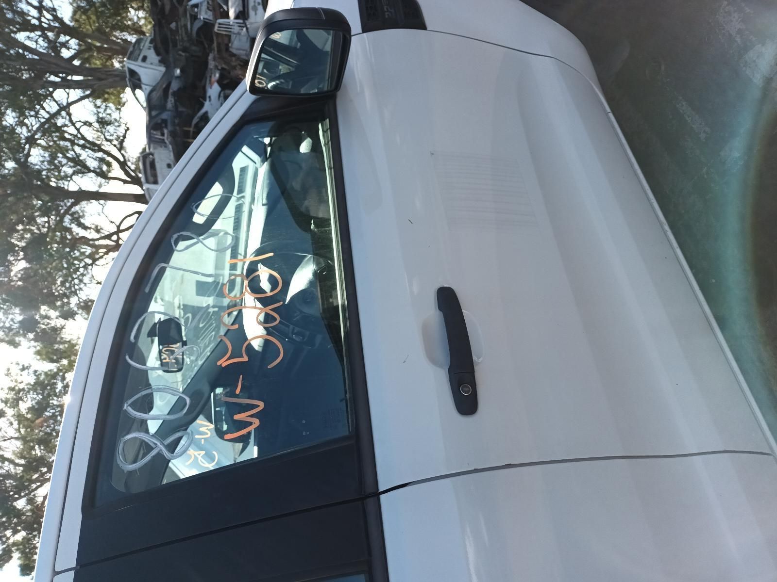 A White Car with a Black Door Handle is Parked on the Side of the Road — South West 4WD Wreckers In Brisbane, QLD
