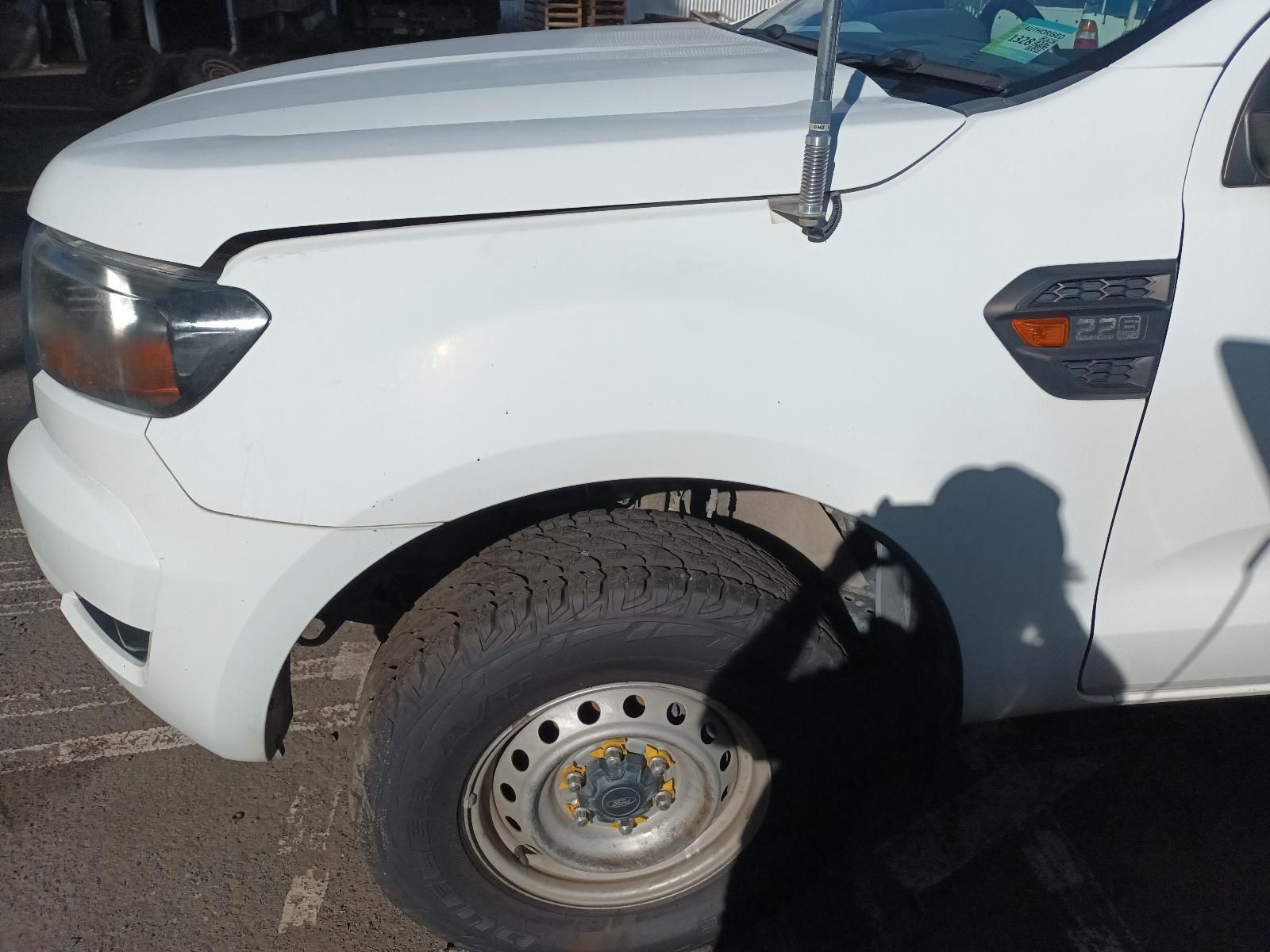 A White Truck with a Broken Fender is Parked in a Parking Lot — South West 4WD Wreckers In Brisbane, QLD
