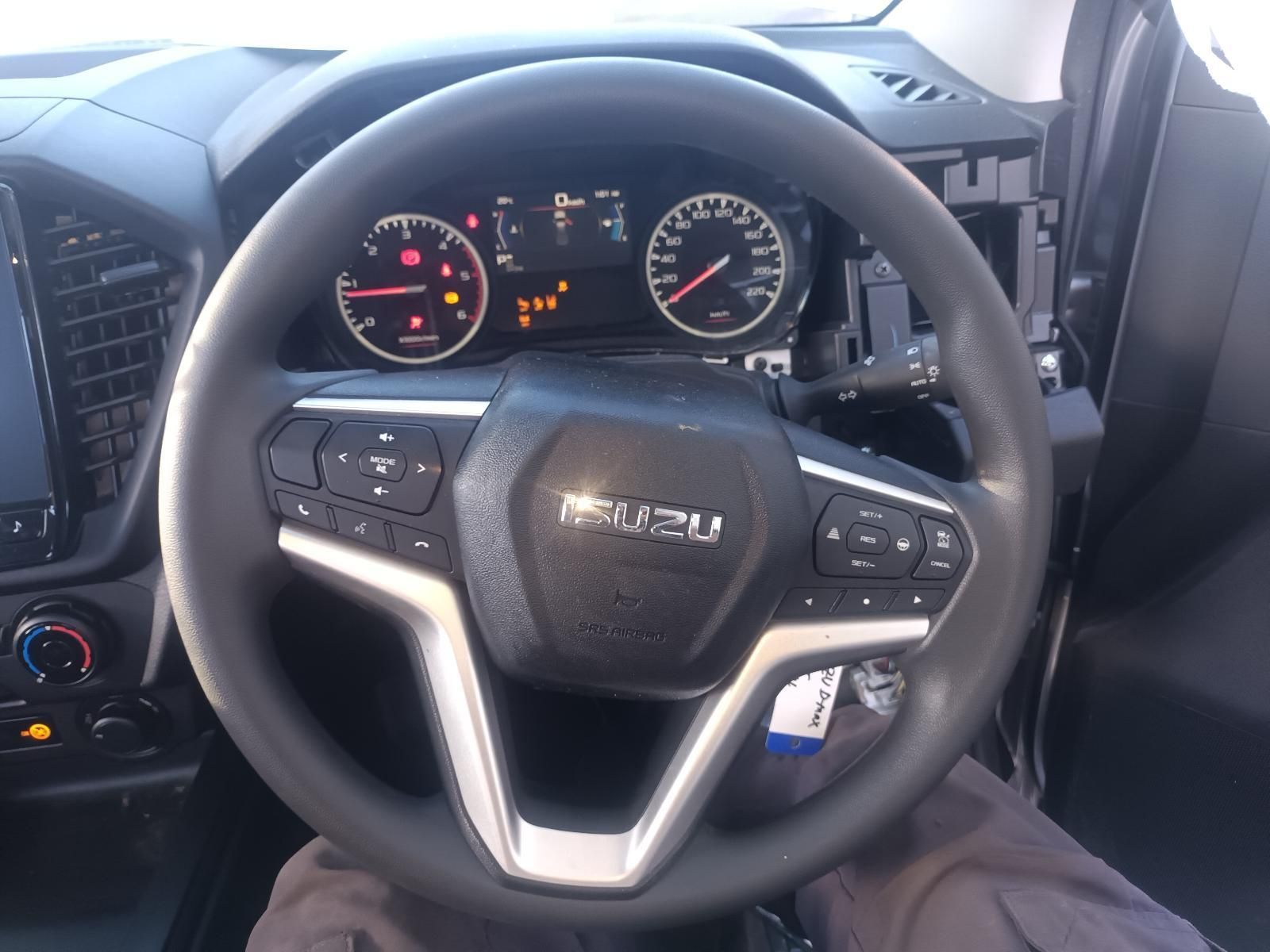 A Person is Sitting in a Car with a Steering Wheel That Says Isuzu on It — South West 4WD Wreckers In Brisbane, QLD