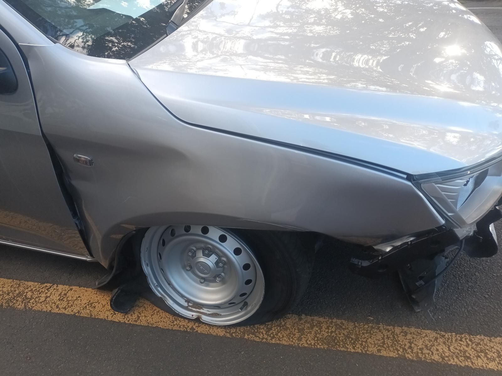 A Silver Car with a Flat Tire is Parked on the Side of the Road — South West 4WD Wreckers In Brisbane, QLD