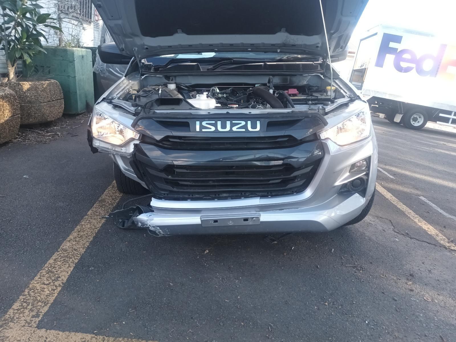 A Gray Isuzu Truck with the Hood Up is Parked in a Parking Lot — South West 4WD Wreckers In Brisbane, QLD