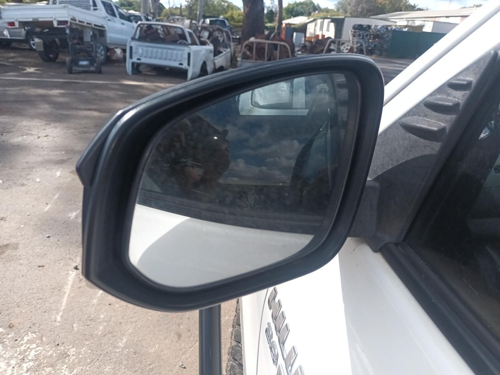 A Side View Mirror on a White Car with a Truck in the Background — South West 4WD Wreckers In Brisbane, QLD