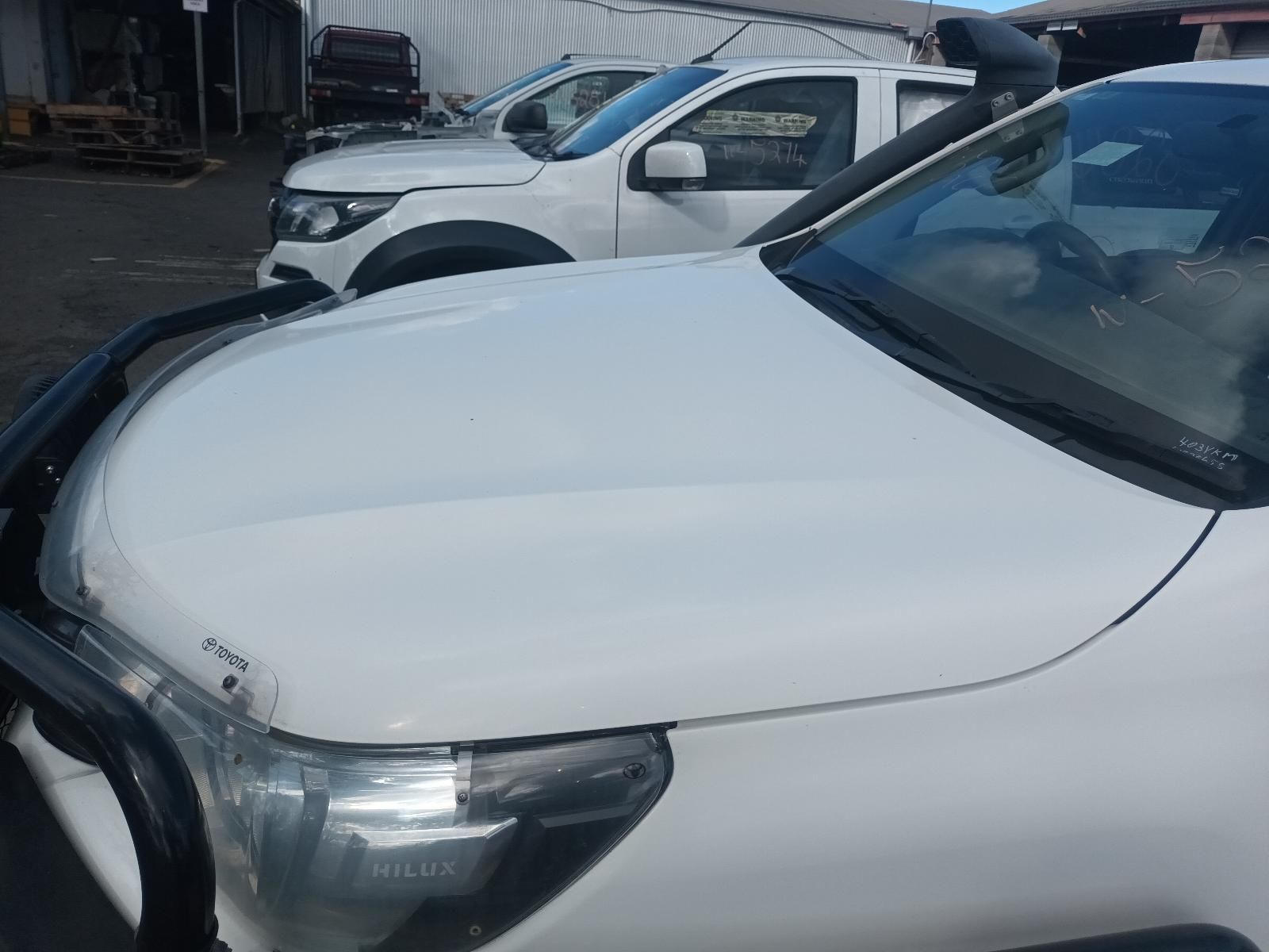 A Row of White Trucks Are Parked in a Parking Lot — South West 4WD Wreckers In Brisbane, QLD