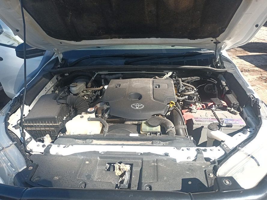 The Engine of a White Car is Shown with the Hood Up — South West 4WD Wreckers In Brisbane, QLD