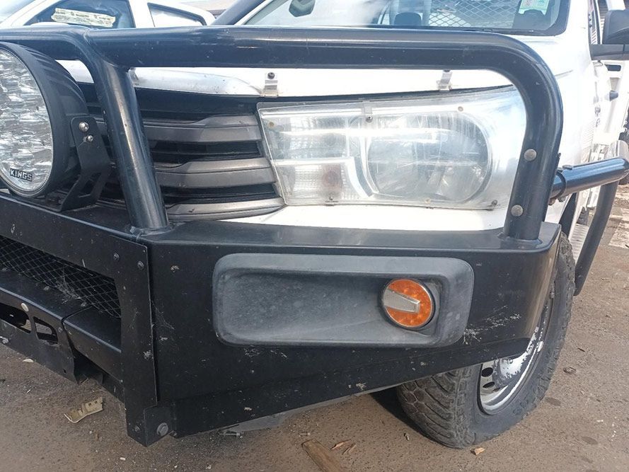 A White Truck with a Black Bumper is Parked on a Dirt Road — South West 4WD Wreckers In Brisbane, QLD