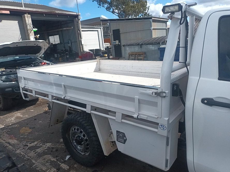 A White Truck with a Flat Bed is Parked in a Parking Lot — South West 4WD Wreckers In Brisbane, QLD