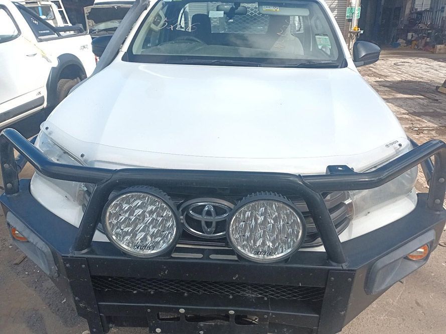 A White Toyota Hilux with a Black Bumper is Parked on the Side of the Road — South West 4WD Wreckers In Brisbane, QLD