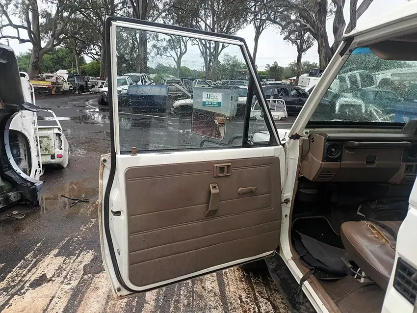 A White Car With the Door Open is Parked in a Lot — South West 4WD Wreckers In Brisbane, QLD