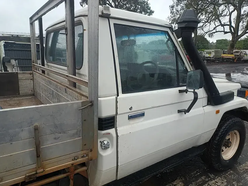 A White Truck With a Flat Bed is Parked in a Parking Lot — South West 4WD Wreckers In Brisbane, QLD
