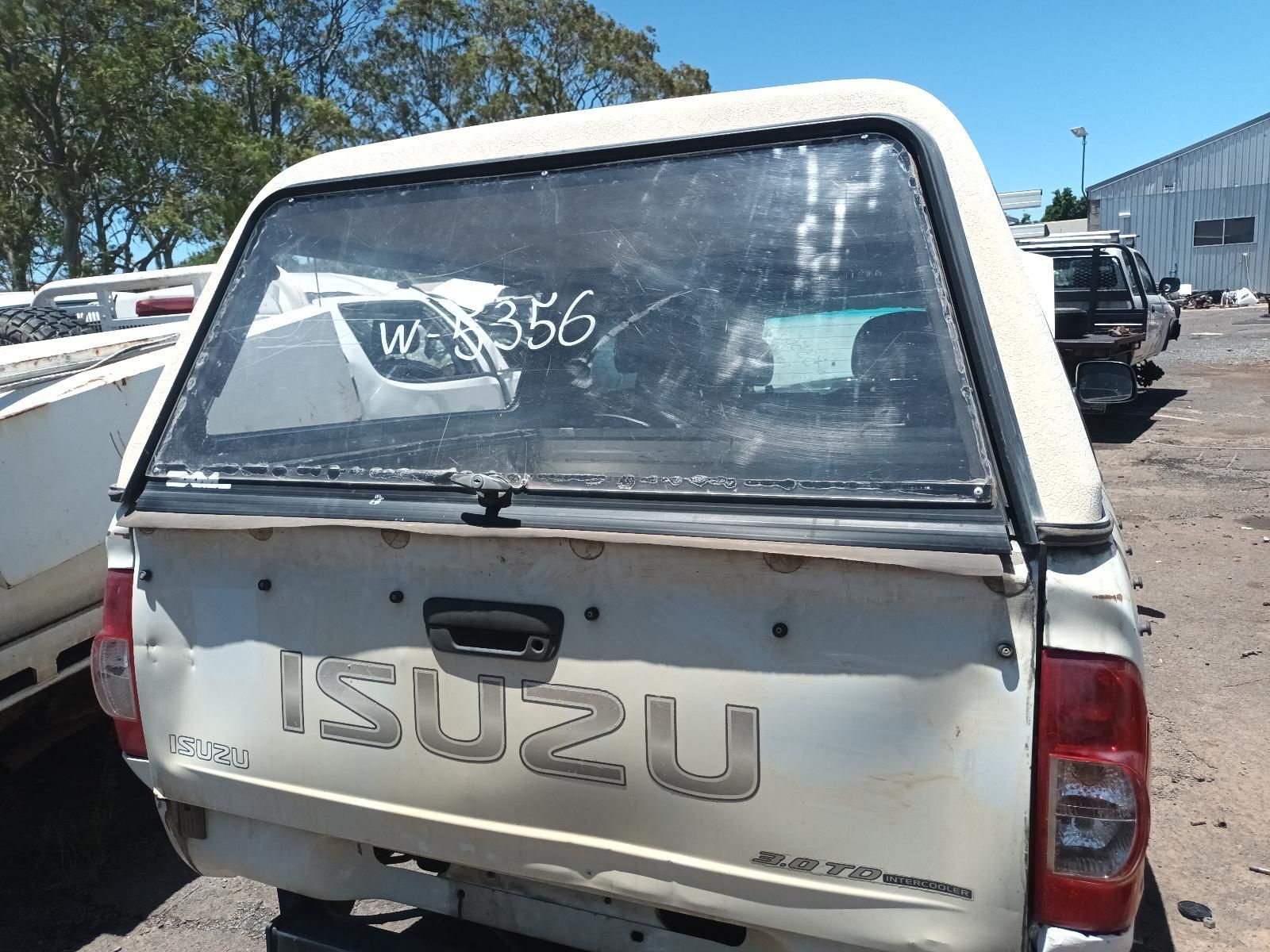 White Isuzu Pickup Truck with A Rear Canopy, Parked Outdoors in A Yard — South West 4WD Wreckers In Harristown, QLD