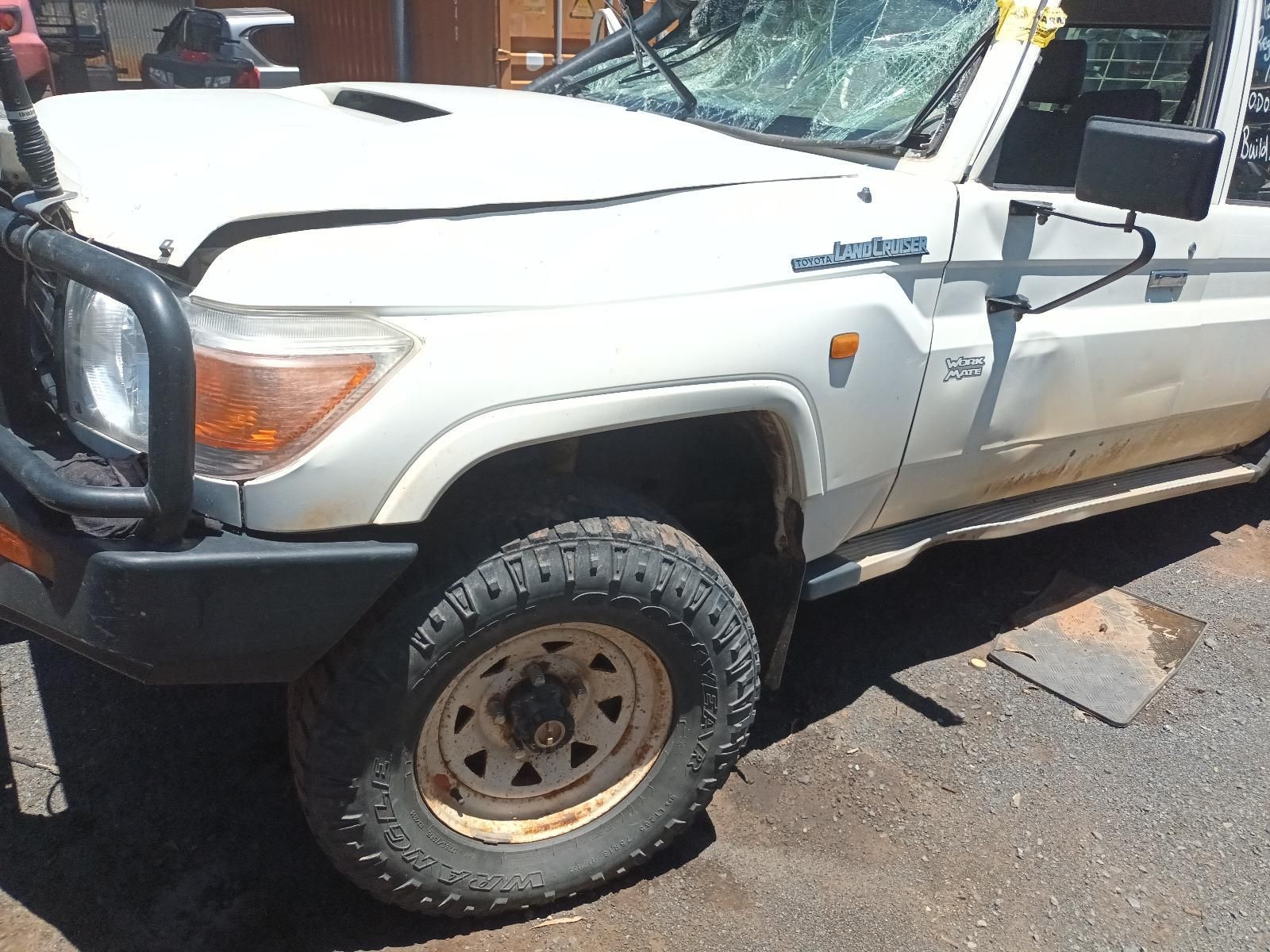 White Off-Road Pickup Truck with Muddy Tires Parked on Pavement, Front Side View — South West 4WD Wreckers In Harristown, QLD
