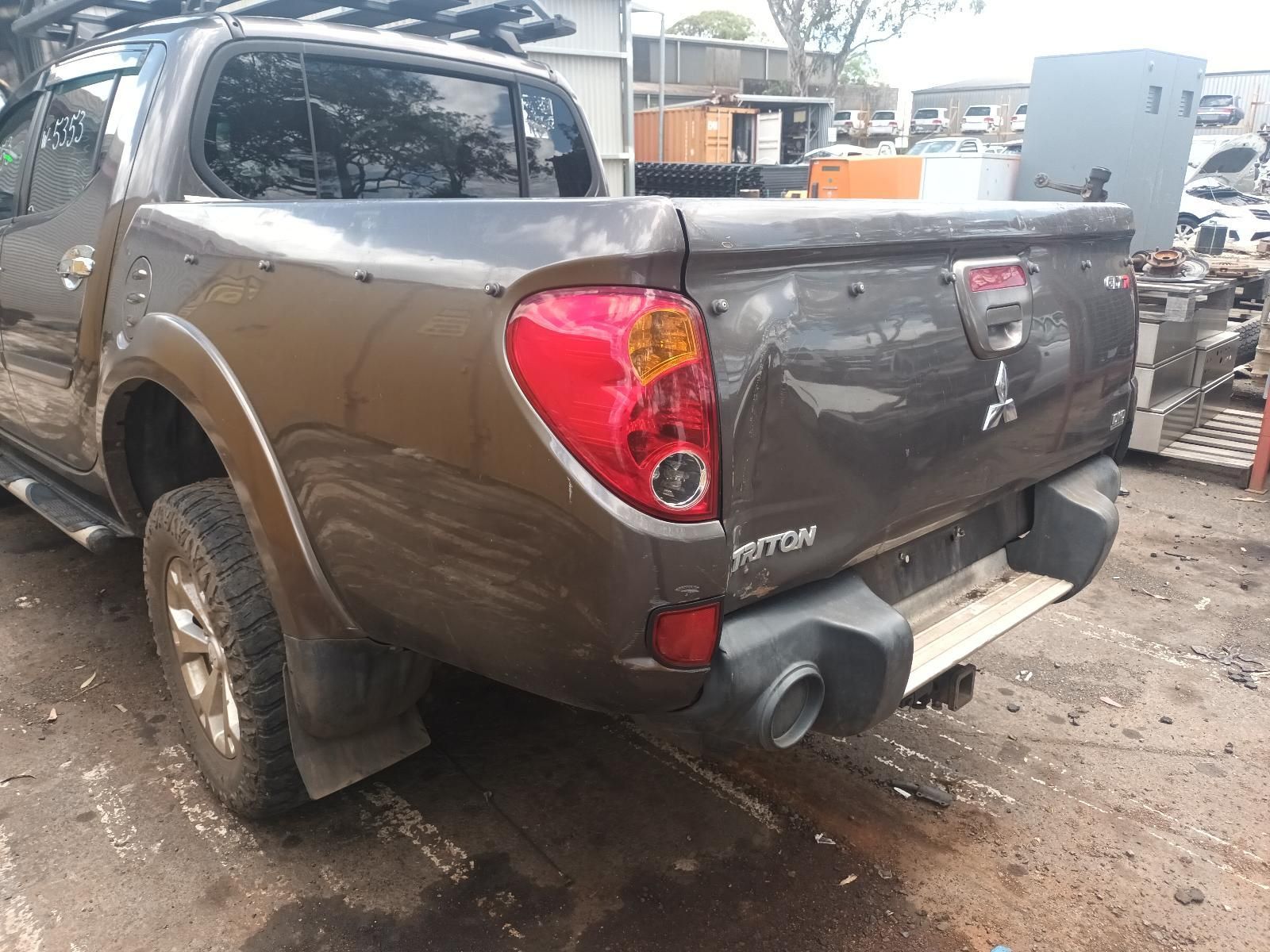 Brown Pickup Truck with Rear Damage Parked in A Muddy Auto Yard — South West 4WD Wreckers In Harristown, QLD
