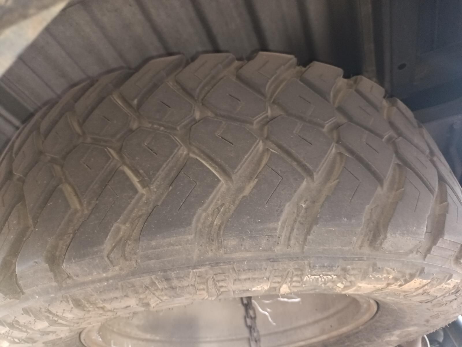 Close-Up of A Dusty Off-Road Tire with Deep Tread Inside a Vehicle Wheel Well — South West 4WD Wreckers In Harristown, QLD