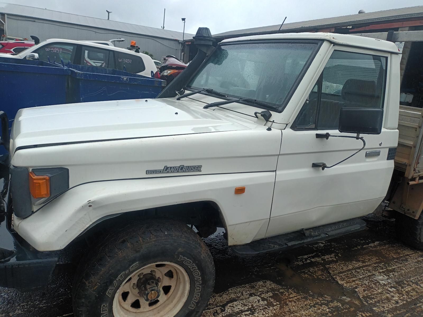 A White Truck is Parked in a Parking Lot Next to a Blue Truck — South West 4WD Wreckers In Brisbane, QLD