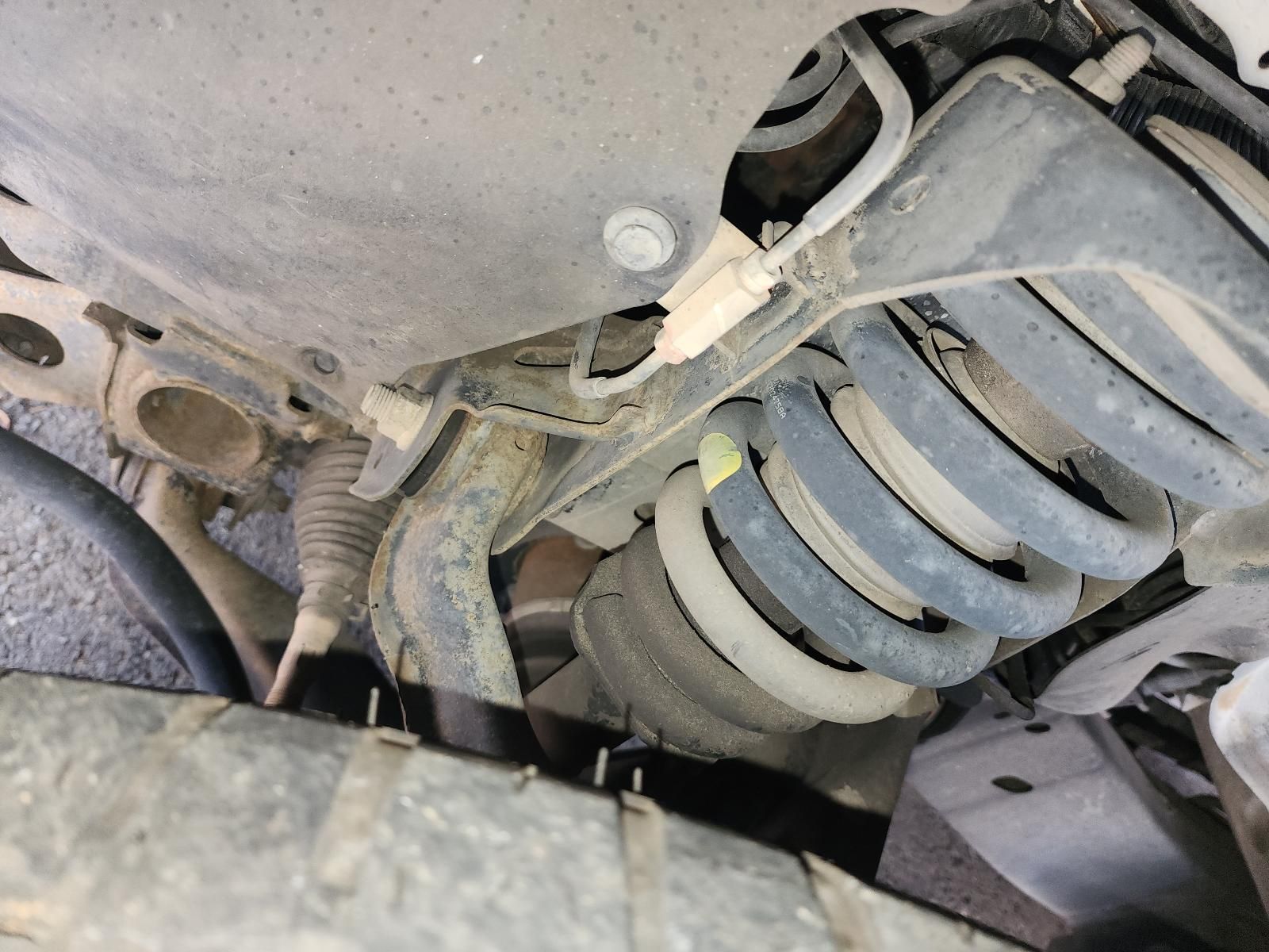 Undercarriage of a Vehicle Showing a Dusty Rear Coil Spring — South West 4WD Wreckers In Harristown, QLD