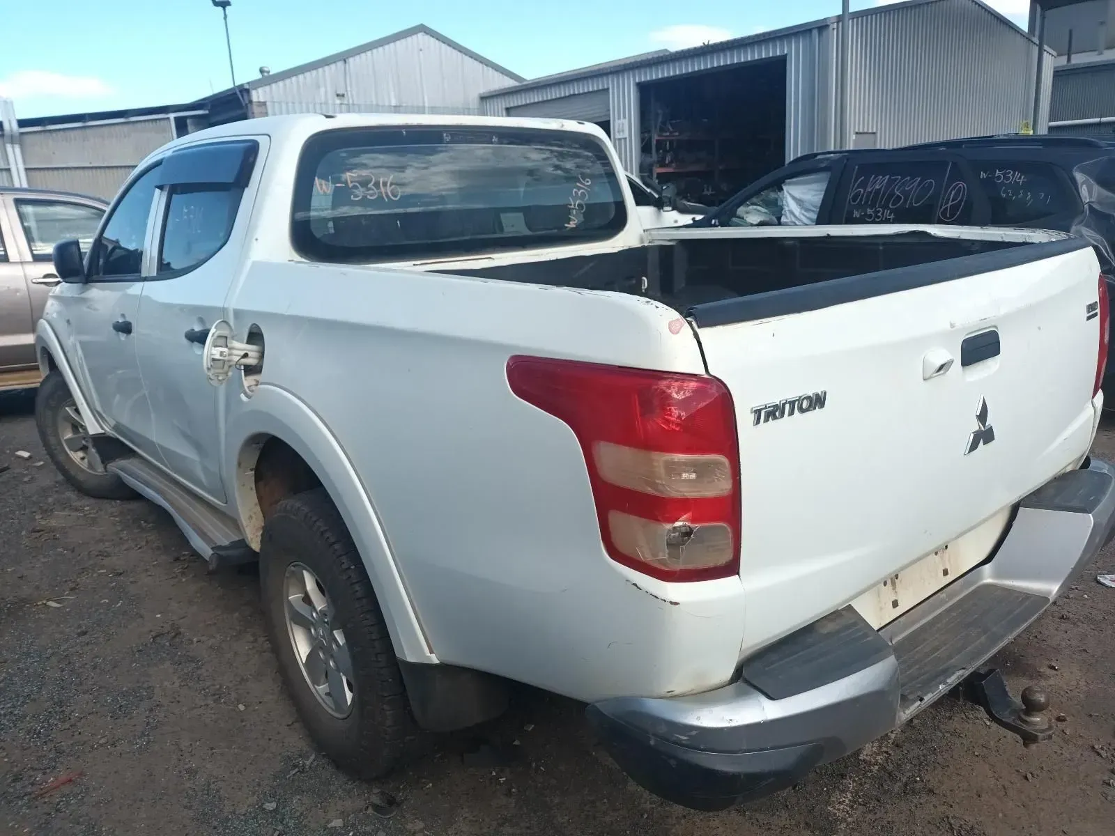 White Mitsubishi Triton Pickup Truck in a Salvage Yard — South West 4WD Wreckers In Harristown, QLD