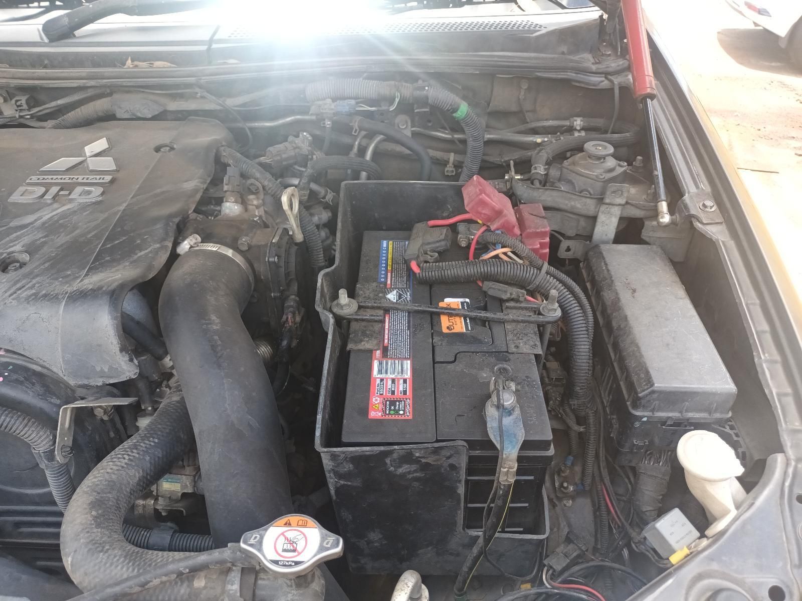 Car Engine Bay with Battery, Hoses, and Wiring Visible Under the Hood — South West 4WD Wreckers In Harristown, QLD