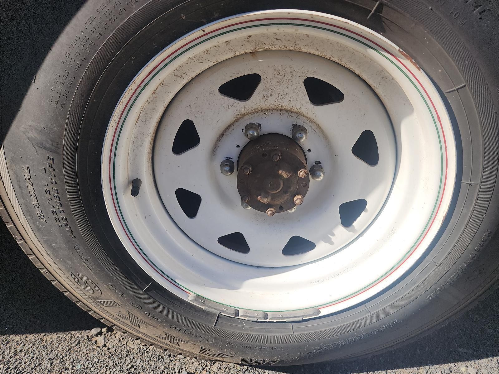 Close-Up of A Truck Wheel with A White Steel Rim and Black Tire on Pavement — South West 4WD Wreckers In Harristown, QLD