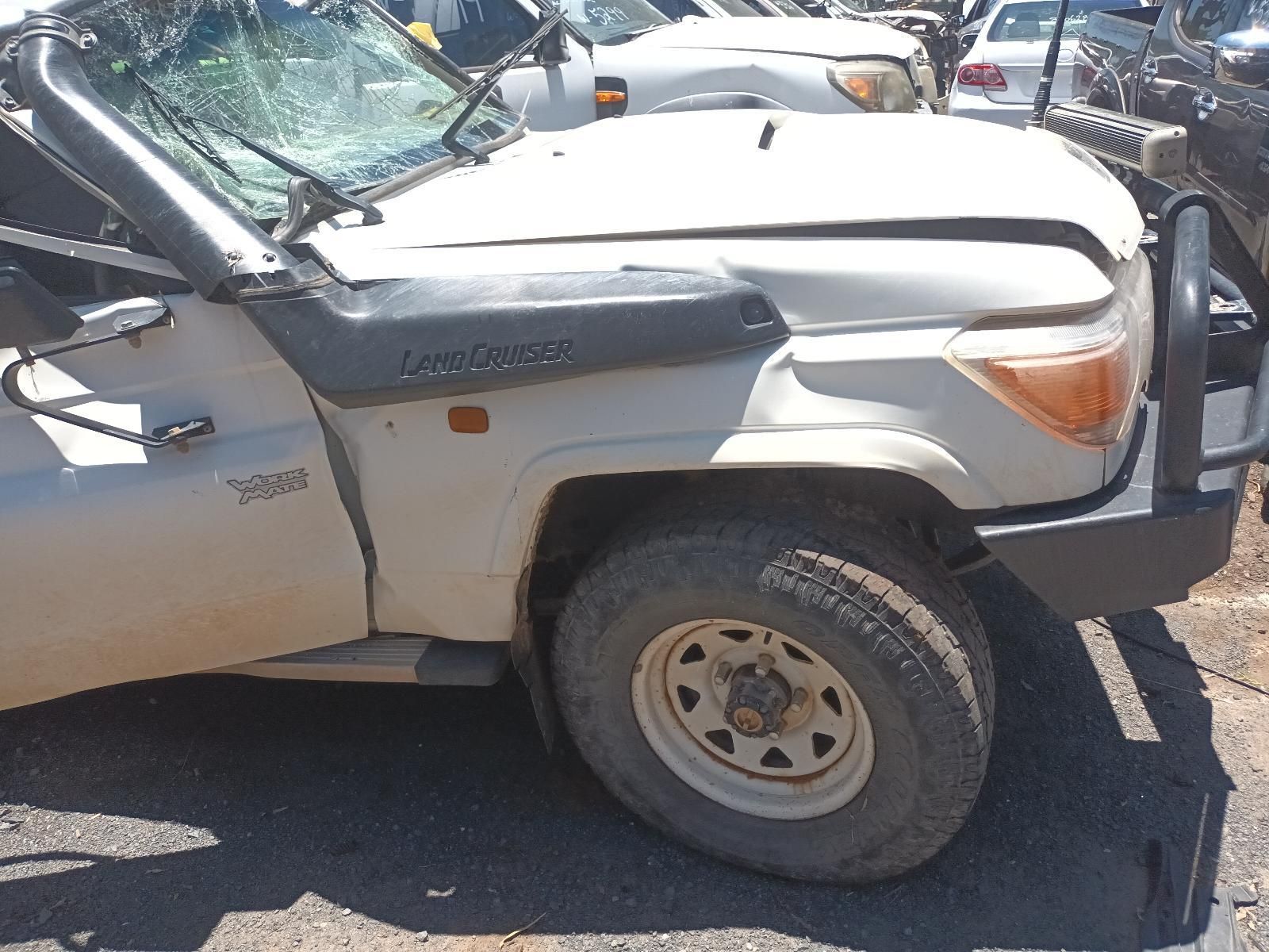 White Suv with A Crumpled Hood and Damaged Front End Parked in A Lot — South West 4WD Wreckers In Harristown, QLD
