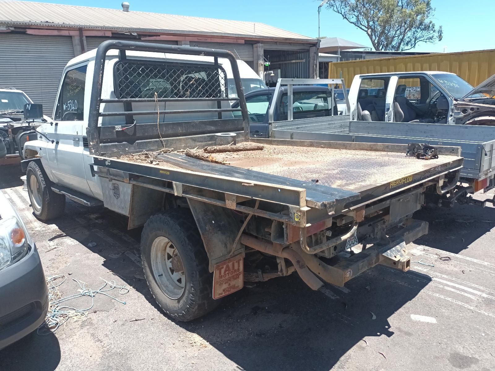Flatbed Pickup Truck with A Damaged Bed Parked in A Sunny Lot — South West 4WD Wreckers In Harristown, QLD