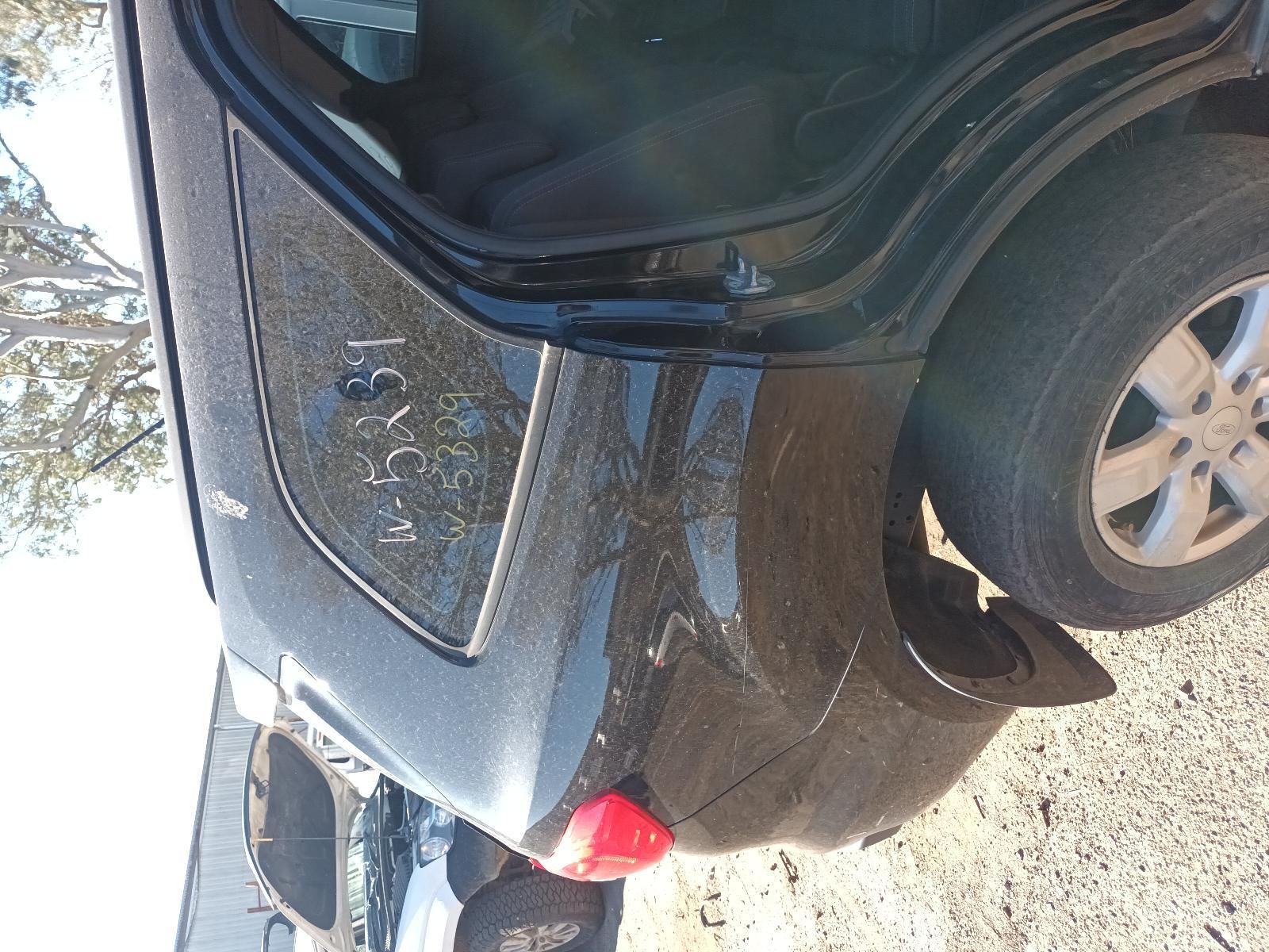 Dark Grey Sedan with Rear Damage and An Open Trunk on A Gravel Roadside — South West 4WD Wreckers In Harristown, QLD