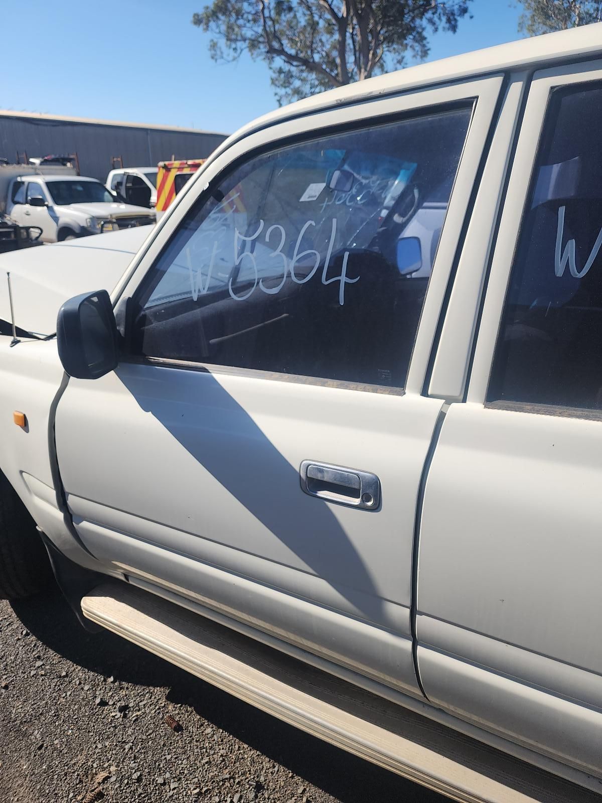 Silver Sedan with White Writing on The Side Window in A Parking Lot — South West 4WD Wreckers In Harristown, QLD