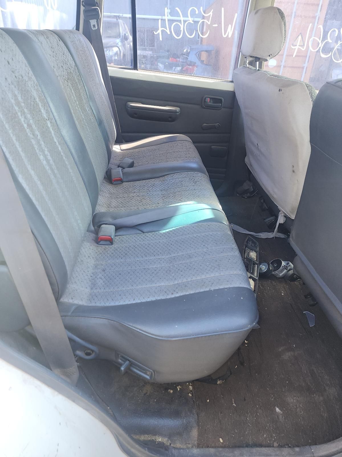 Back Seat of A Car with Grey Fabric Seats and Clutter on The Floor — South West 4WD Wreckers In Harristown, QLD