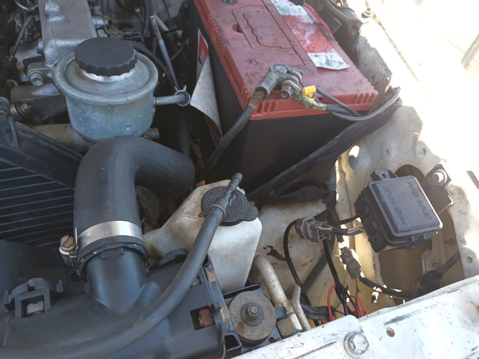 Car Engine Bay with Battery, Hoses, Air Filter, and Other Mechanical Components — South West 4WD Wreckers In Harristown, QLD