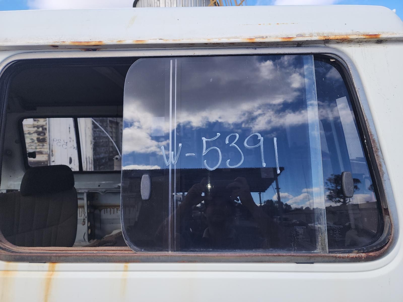 Worn Bus Window With Cloudy Sky Reflection — South West 4WD Wreckers In Harristown, QLD