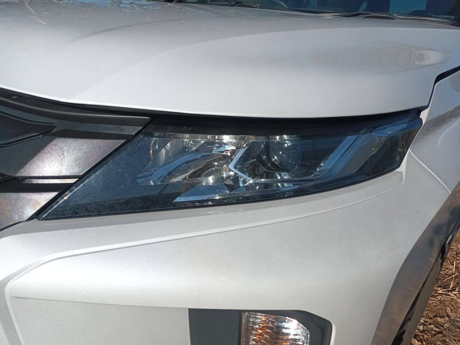 Close-Up of A White Car’s Front Headlight and Bumper — South West 4WD Wreckers In Harristown, QLD