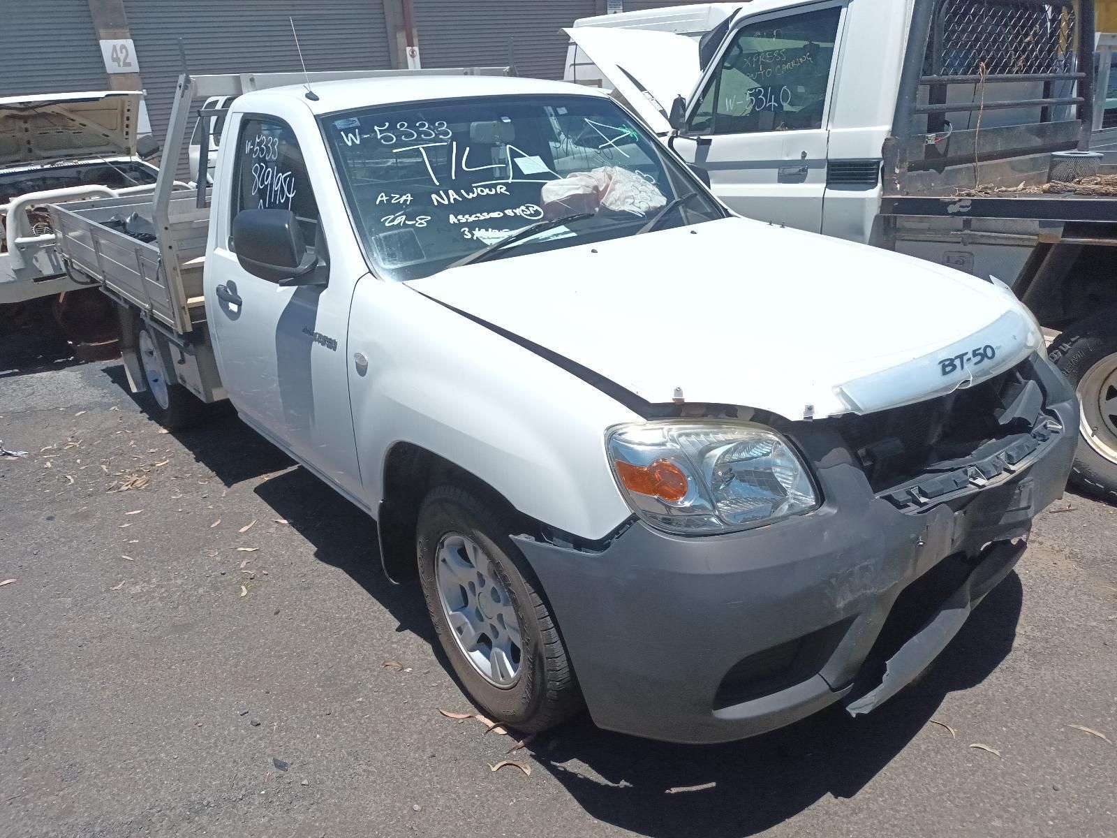 White Pickup Truck with Front-End Damage Parked in A Lot — South West 4WD Wreckers In Harristown, QLD
