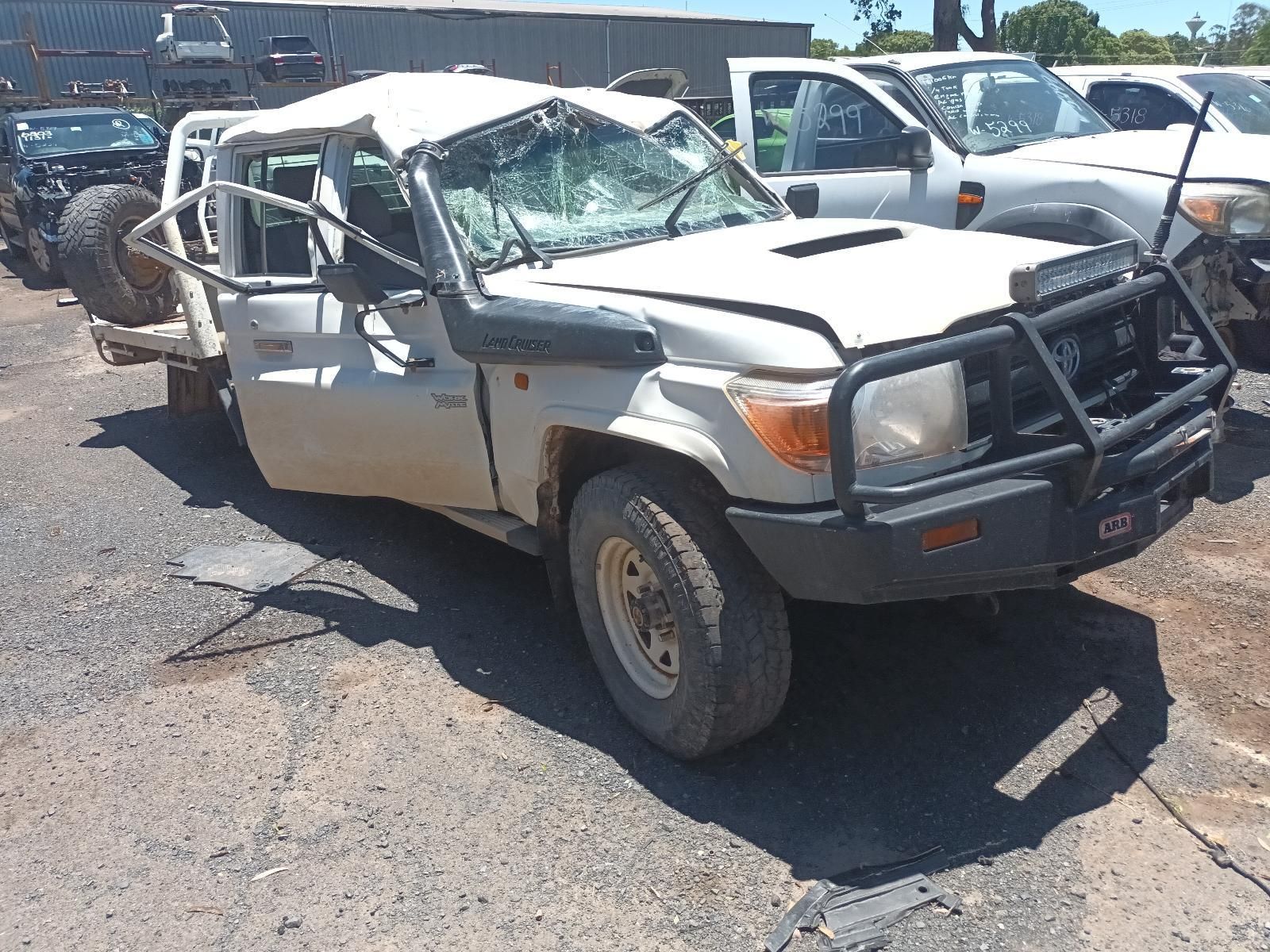 Damaged White Suv with Roll Cage and Crushed Front End in A Parking Lot — South West 4WD Wreckers In Harristown, QLD