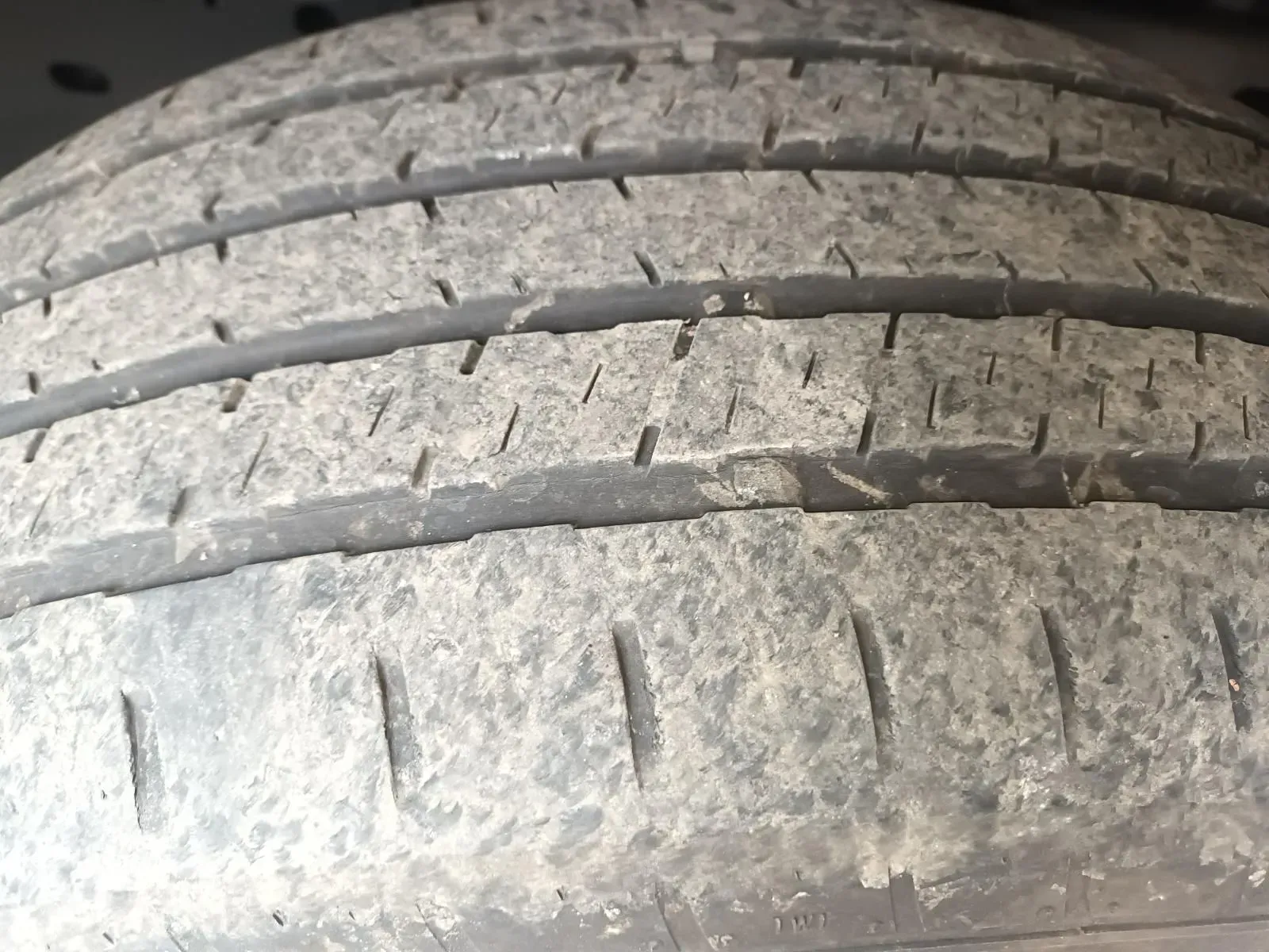 Close-up of a Dirty, Worn Tyre Showing Visible Tread Wear and Small Cracks — South West 4WD Wreckers In Harristown, QLD