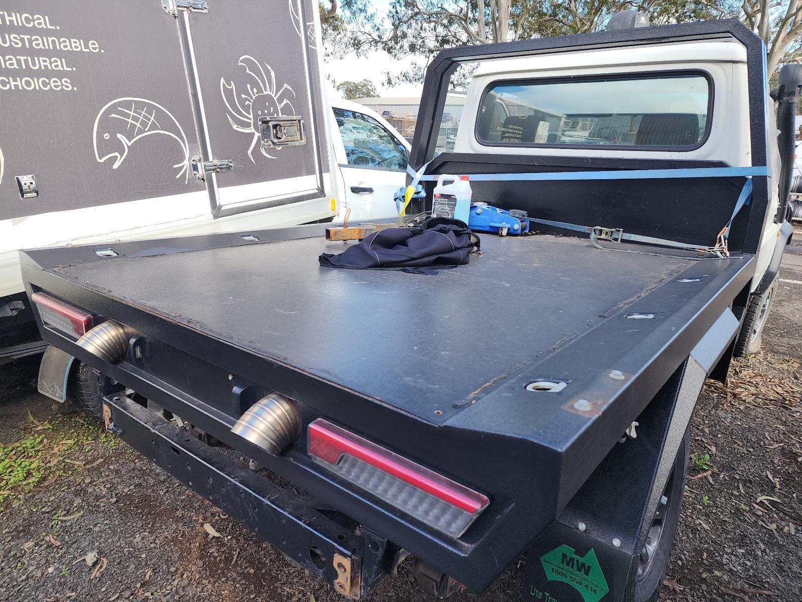 Black Flatbed Truck Parked Beside a Chalkboard Wall — South West 4WD Wreckers In Harristown, QLD