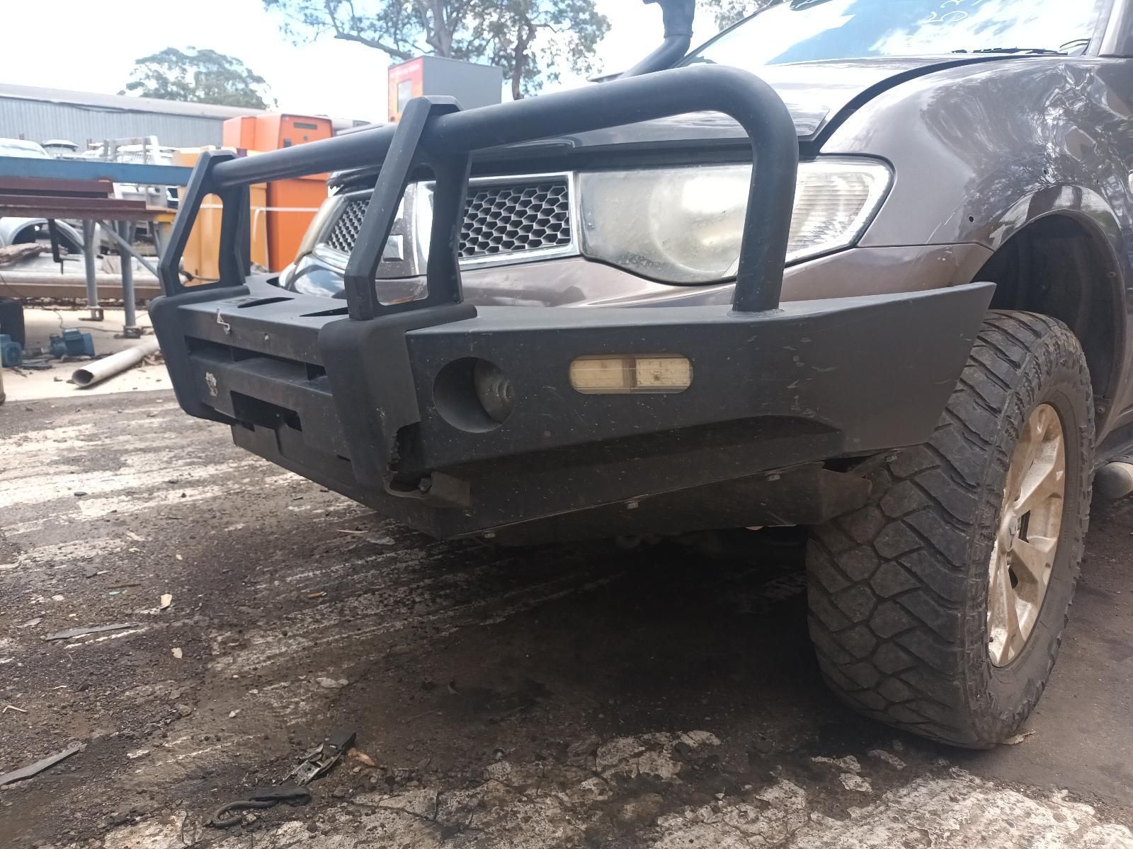 Front View of A Brown Suv with An Off-Road Bumper and Large Tires on A Dirt Lot — South West 4WD Wreckers In Harristown, QLD