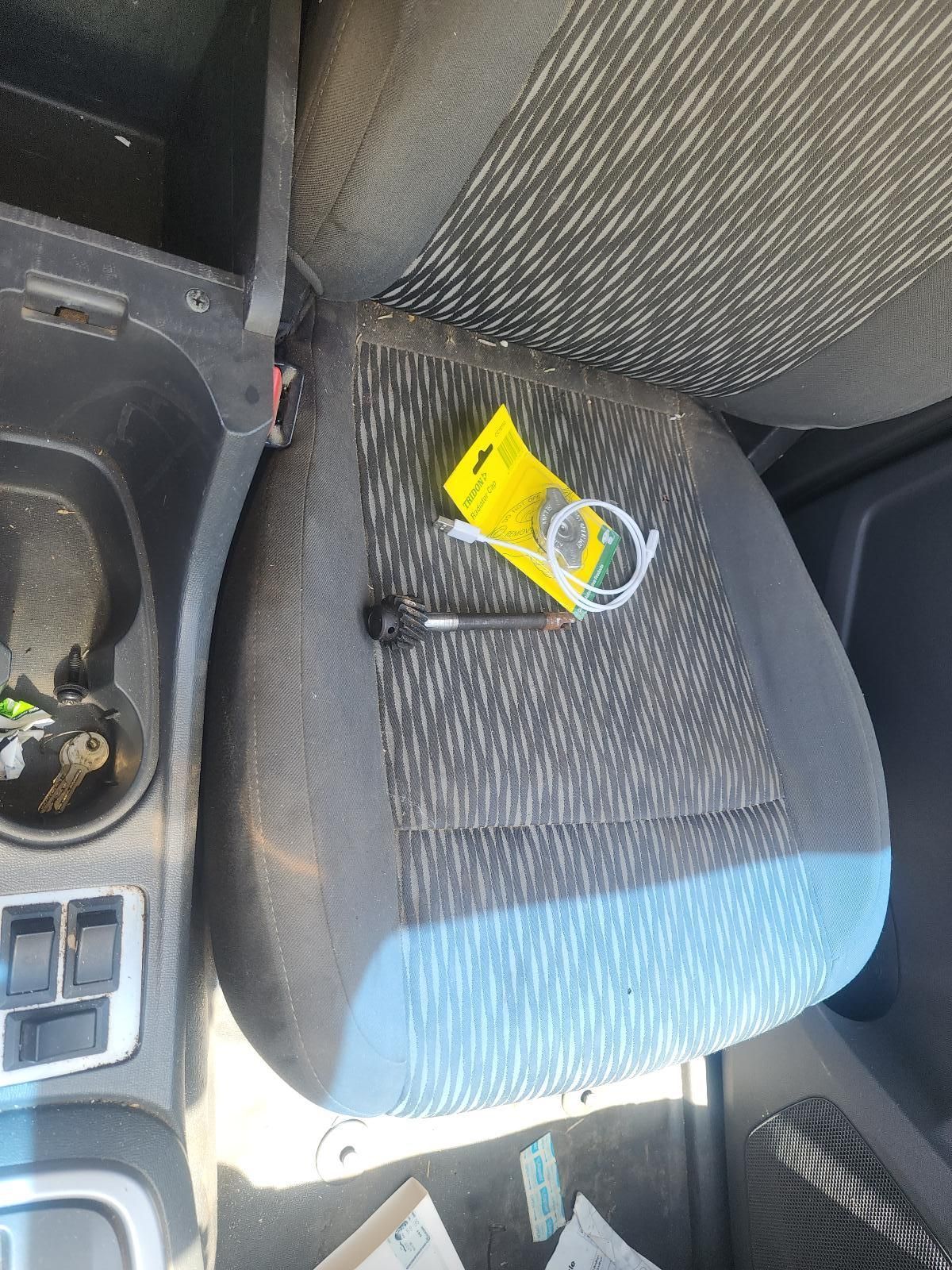 Car Key and Yellow Wrapper on a Gray Cloth Car Seat — South West 4WD Wreckers In Harristown, QLD