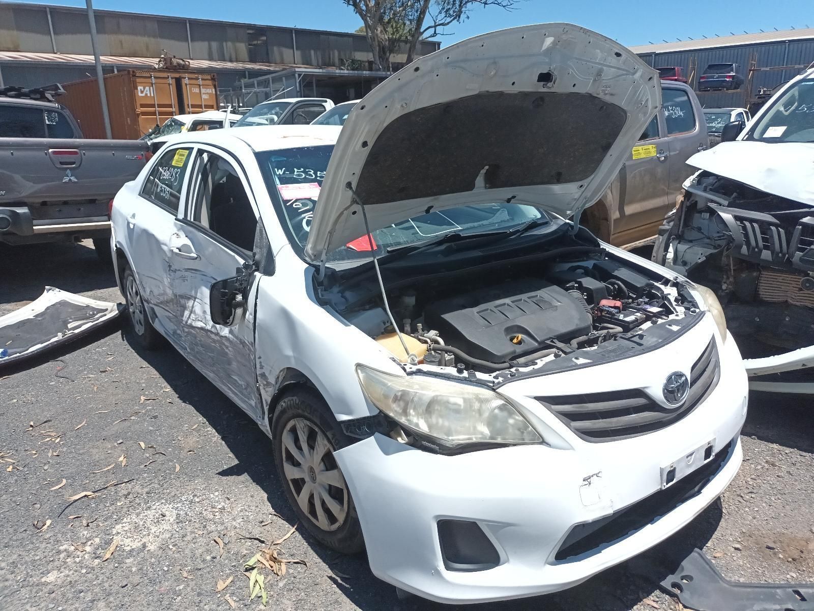 White Sedan with Open Hood and Visible Front Damage in A Salvage Yard — South West 4WD Wreckers In Harristown, QLD