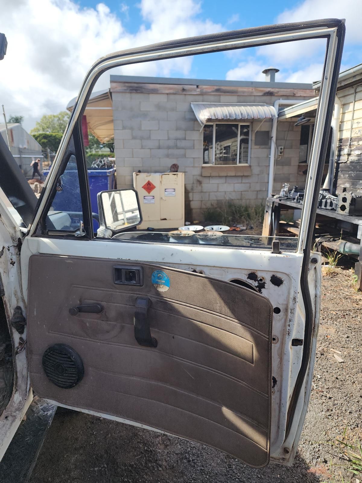 Damaged Car Door Leaning Upright in a Gravel Yard — South West 4WD Wreckers In Harristown, QLD