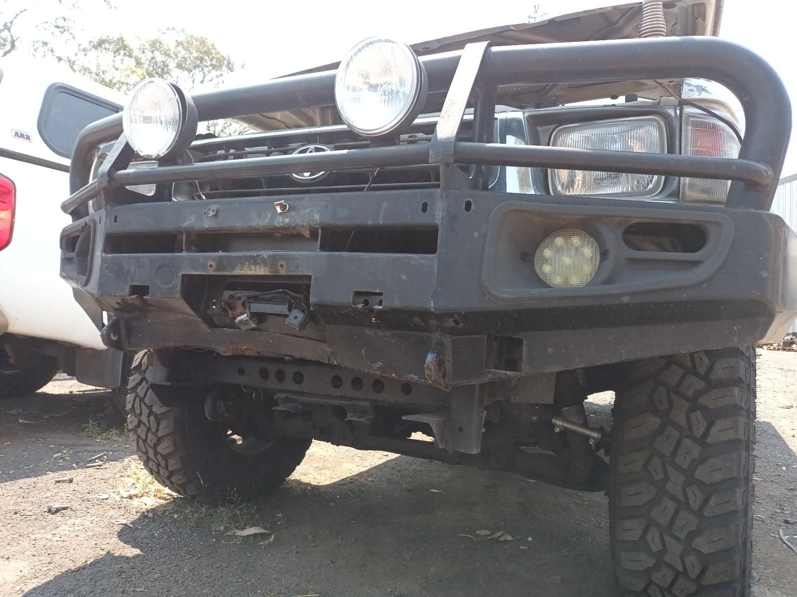 Off-Road Truck with Heavy Bumper and Large Tyres Parked Outdoors — South West 4WD Wreckers In Harristown, QLD