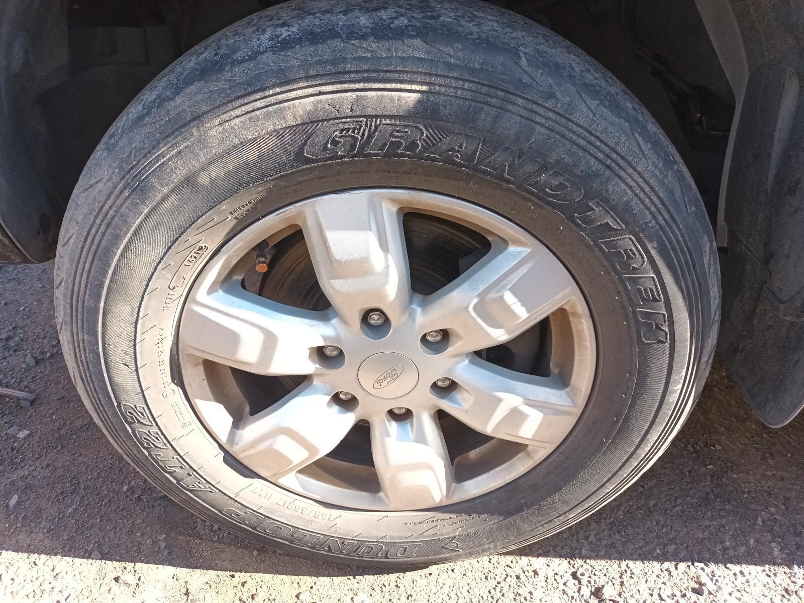 Close-Up of A Car Tyre and Silver Alloy Wheel on A Dusty Pavement — South West 4WD Wreckers In Harristown, QLD