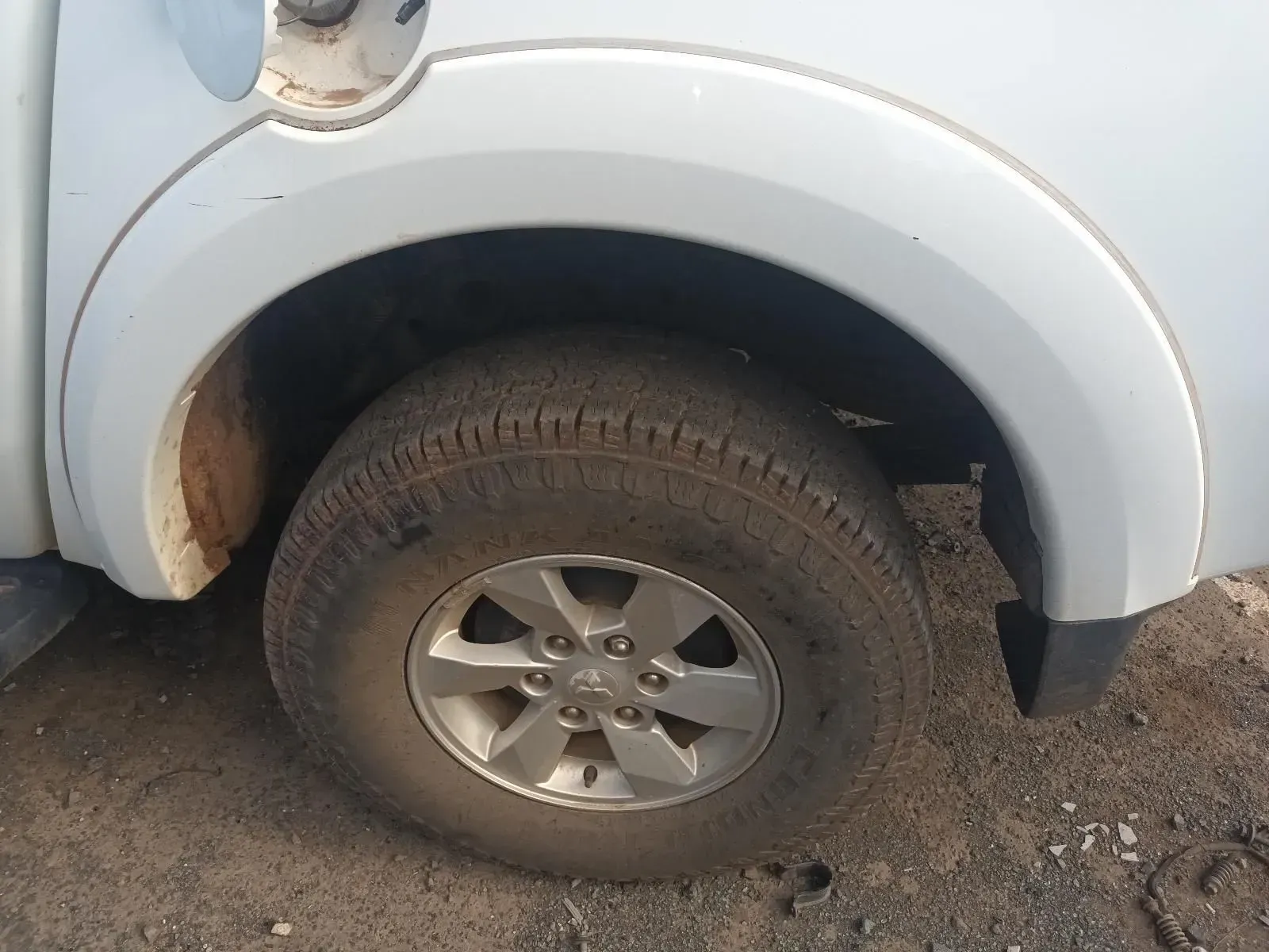 Close-up of a Dirty Tyre and Wheel on a White Truck With a Curved Fender — South West 4WD Wreckers In Harristown, QLD