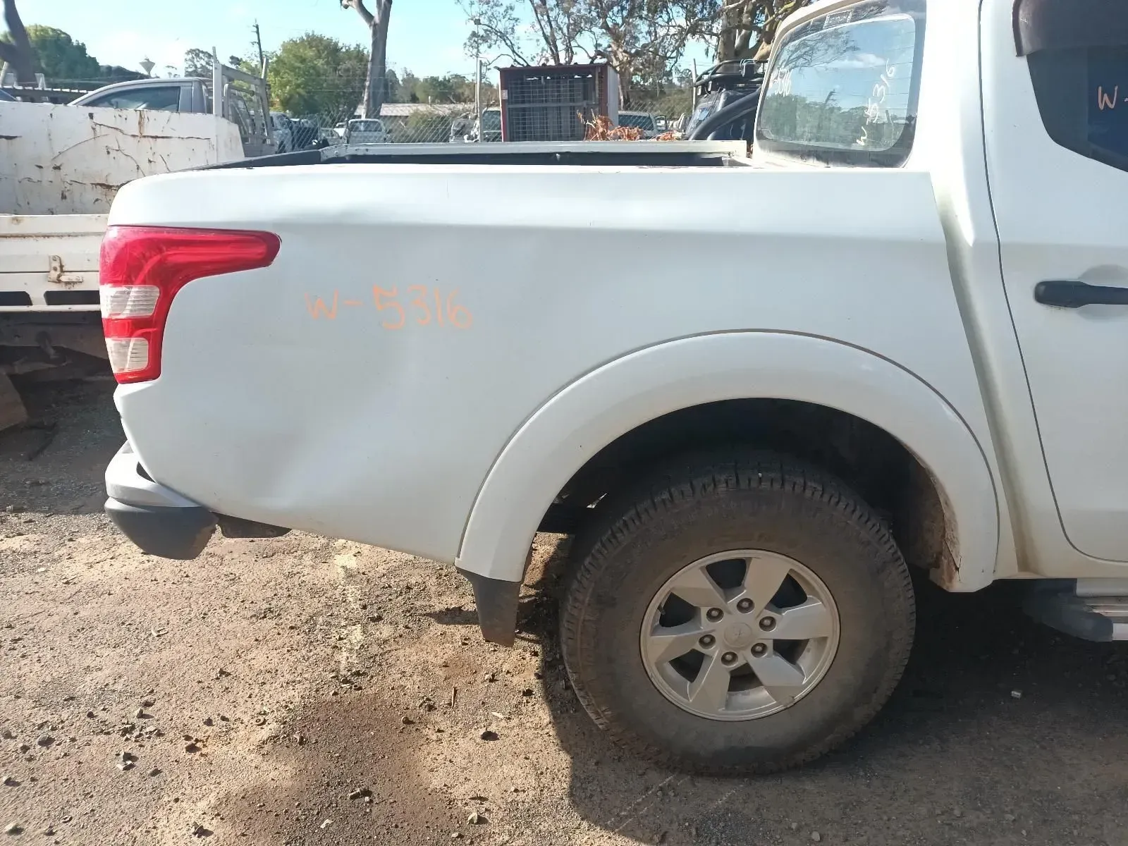 White Pickup Truck With Rear Damage, Parked Outdoors on Dirt — South West 4WD Wreckers In Harristown, QLD