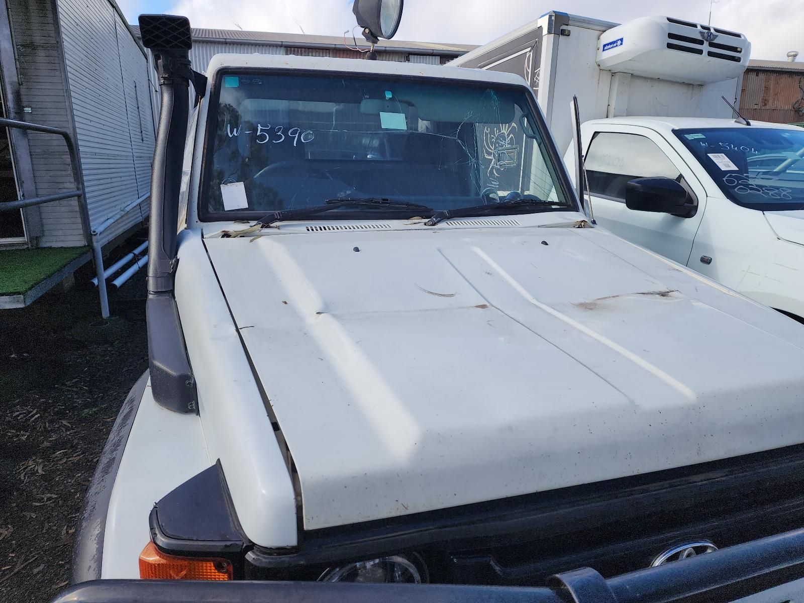 White Pickup Truck Parked Tightly Between Vehicles — South West 4WD Wreckers In Harristown, QLD